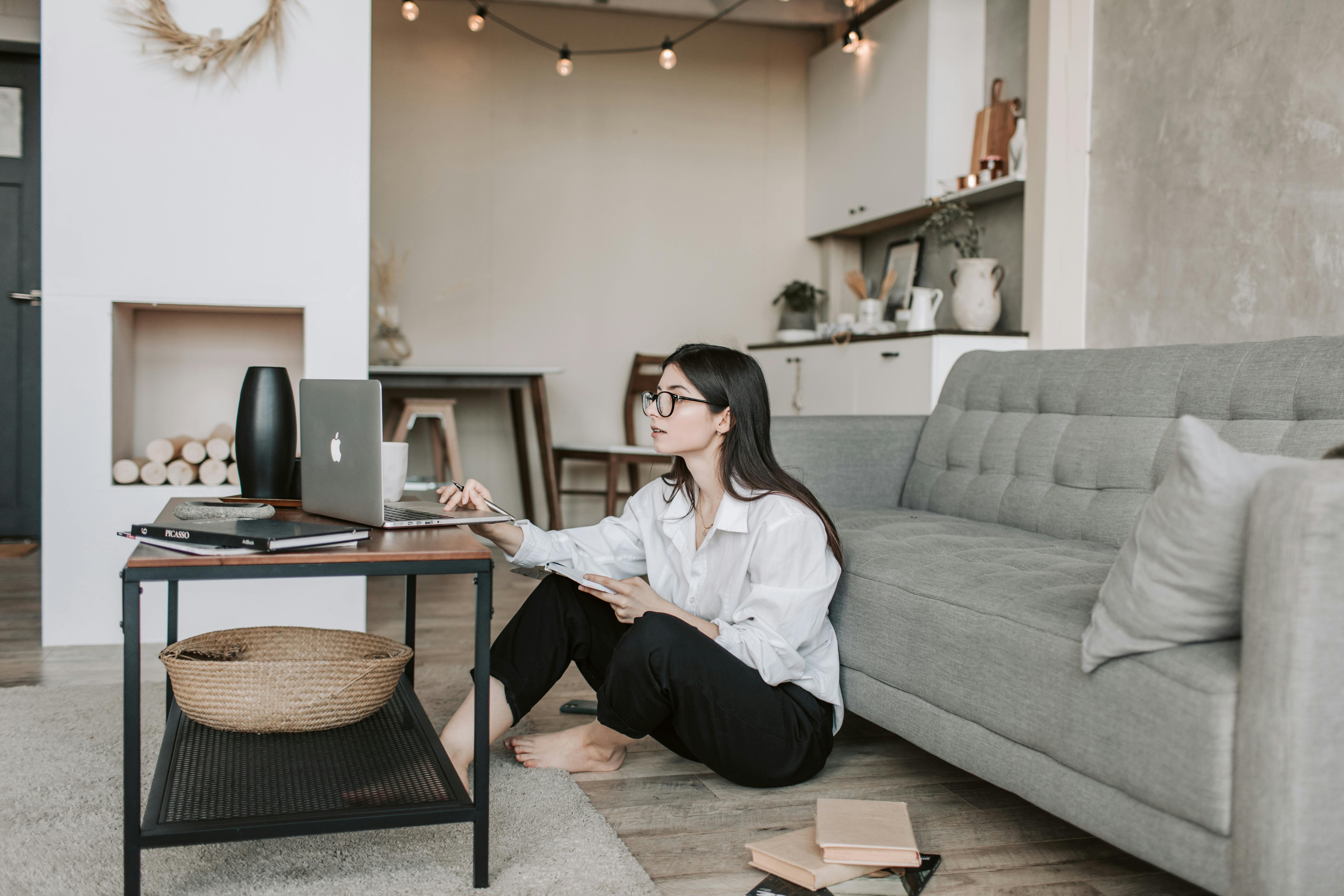 woman sitting on the floor while using her laptop