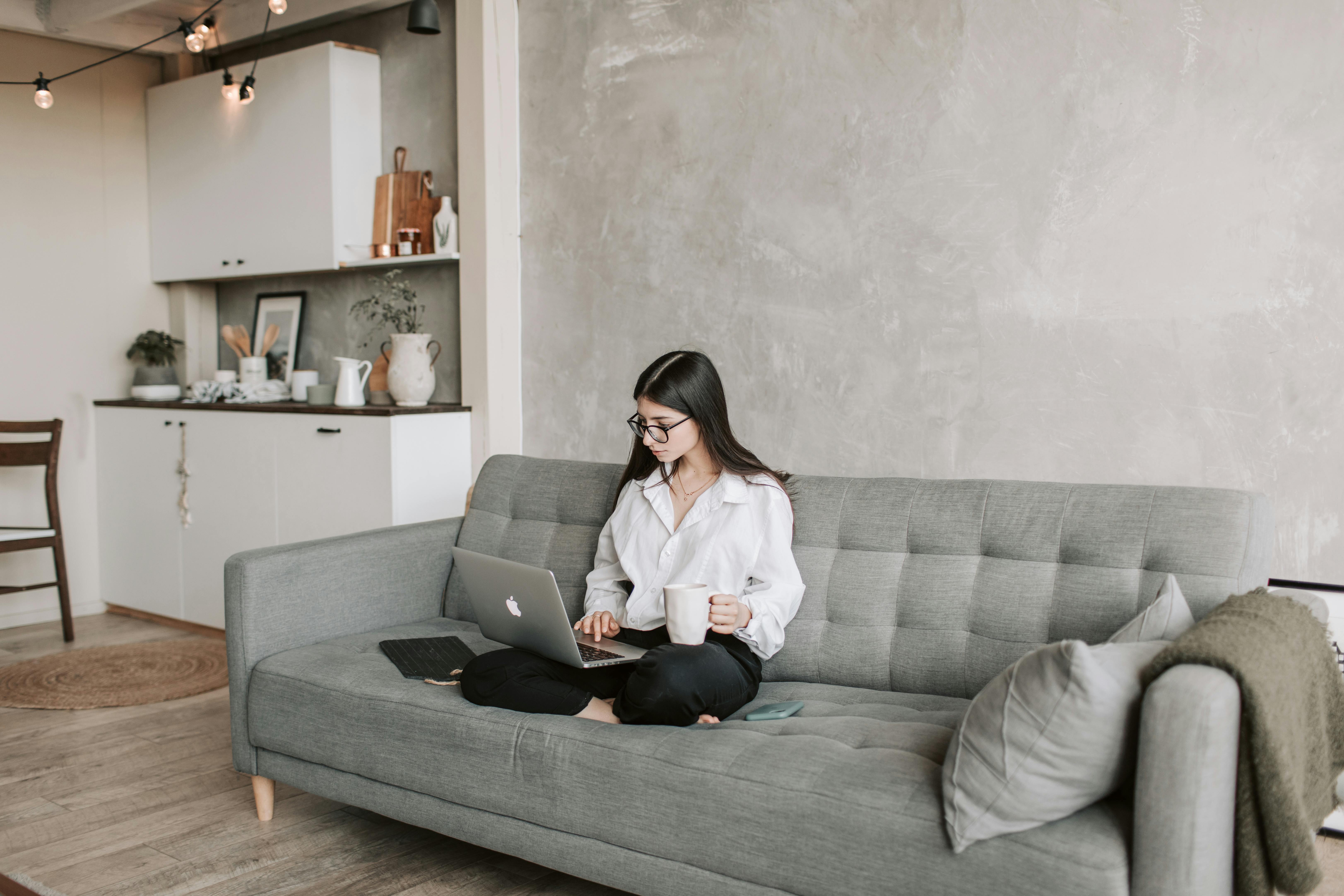 woman sitting on sofa while working at home