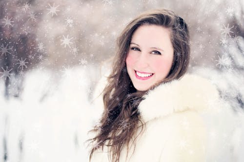 gratis Vrouw In Wit Bontjasje Dat Vooraan Glimlacht Stockfoto