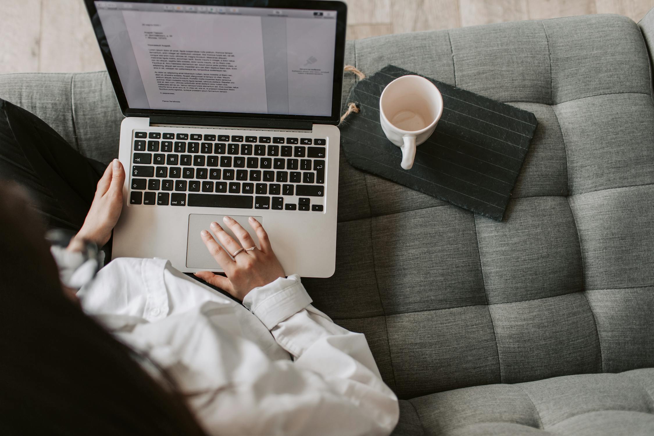 Image of a woman using laptop on sofa at home