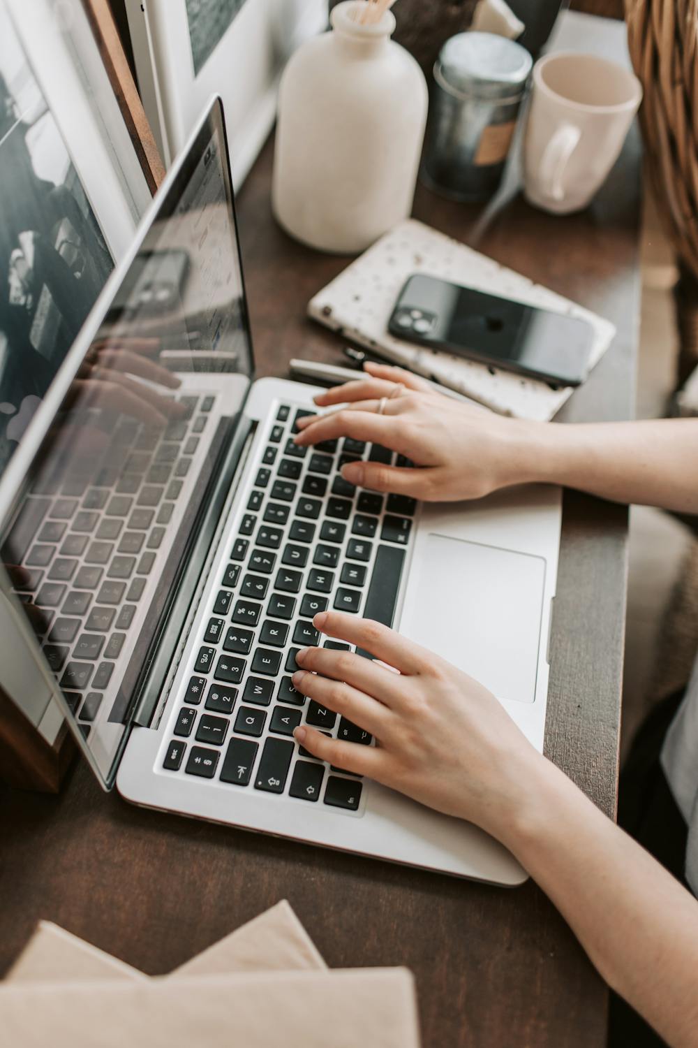 Hands typing on laptop keyboard