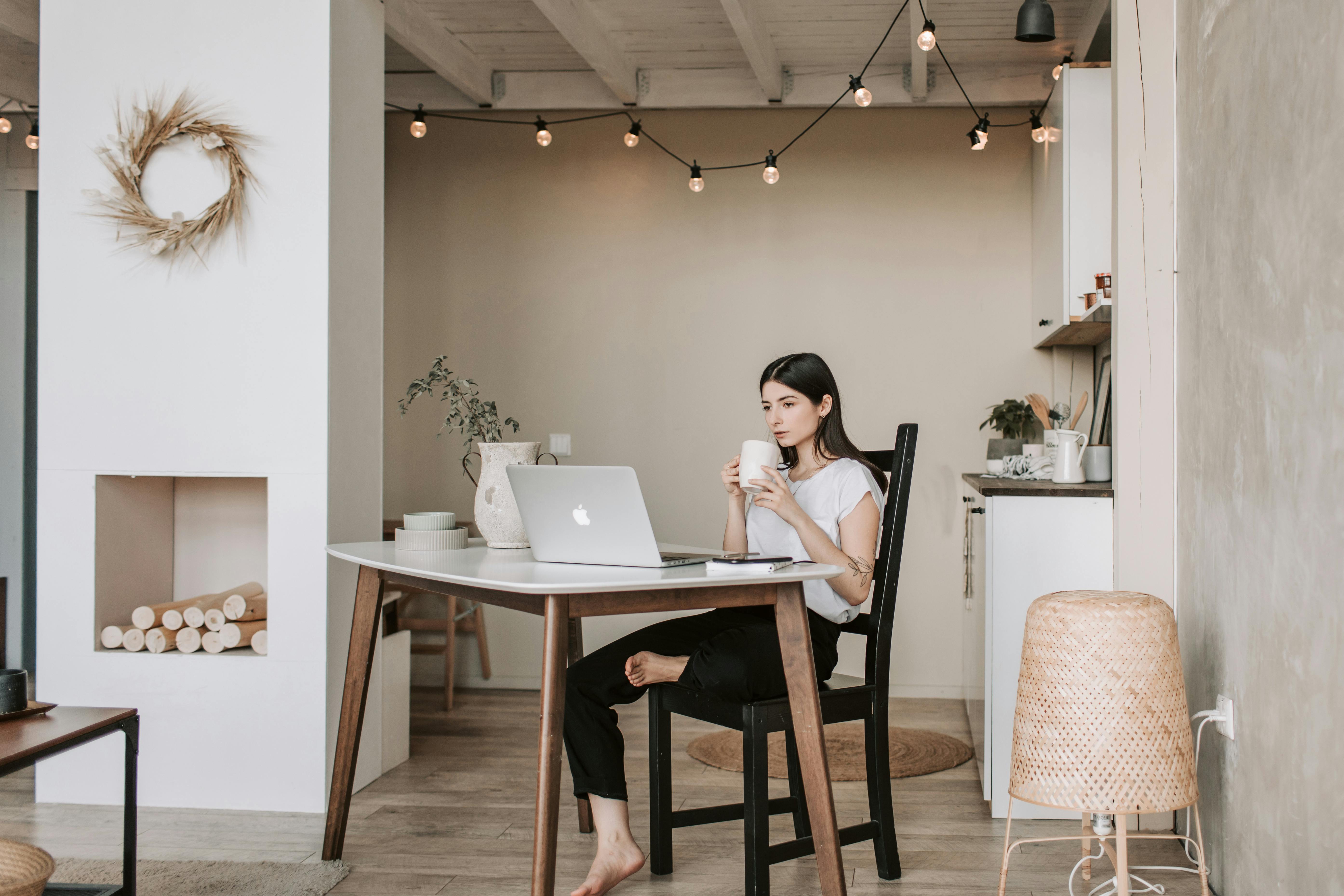 focused young woman drinking coffee in cozy living room