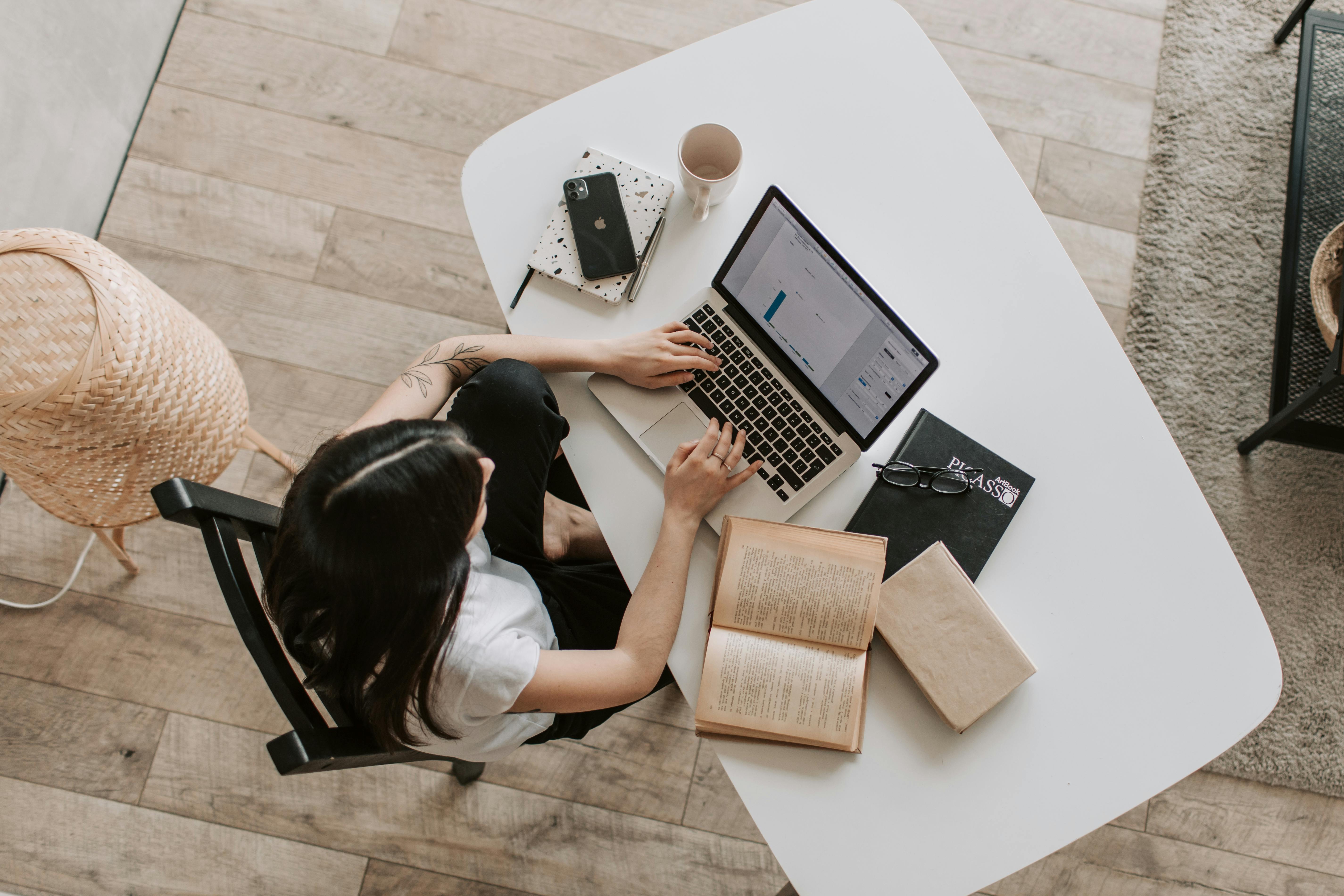 A woman is using a laptop in the living room. | Photo: Pexels