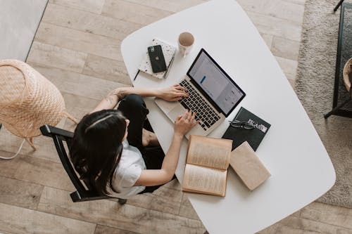 Free Young lady typing on keyboard of laptop in living room Stock Photo