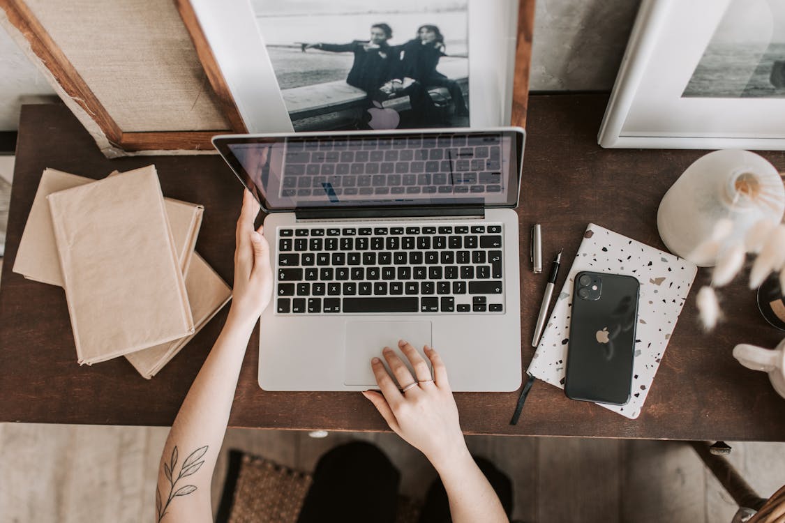 Free Unrecognizable lady using laptop in workspace Stock Photo