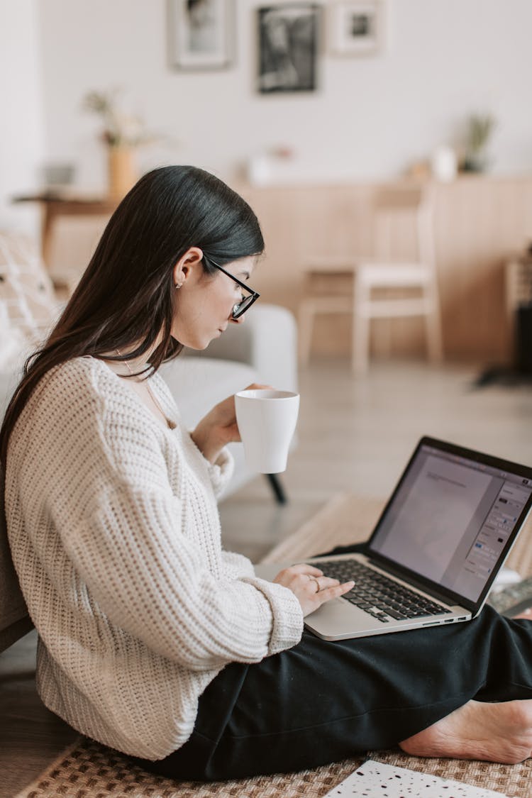 Young Barefoot Woman Using Laptop On Floor In Living Room