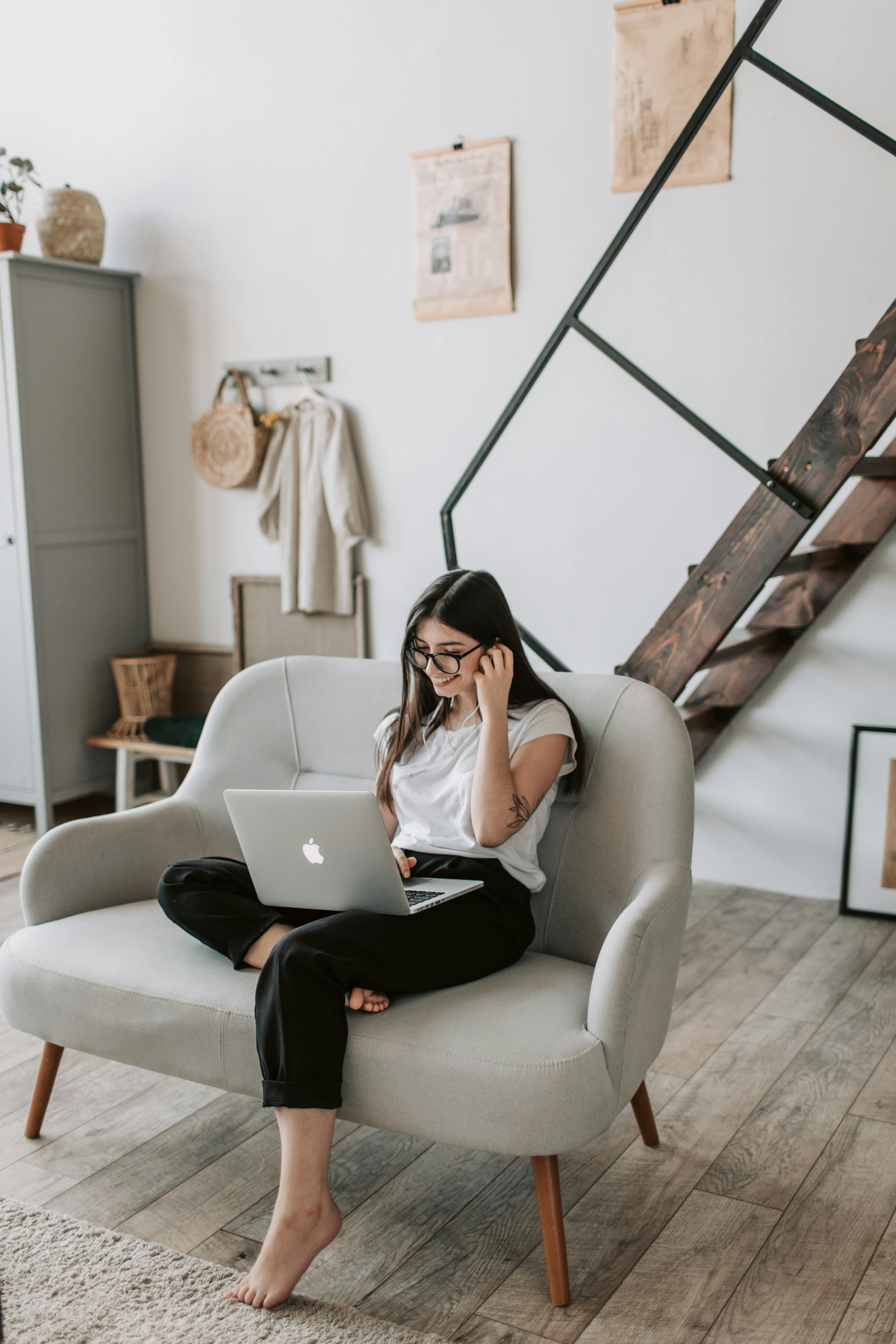 happy woman using laptop in cozy living room at home