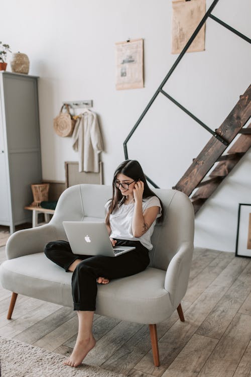 Free Happy woman using laptop in cozy living room at home Stock Photo