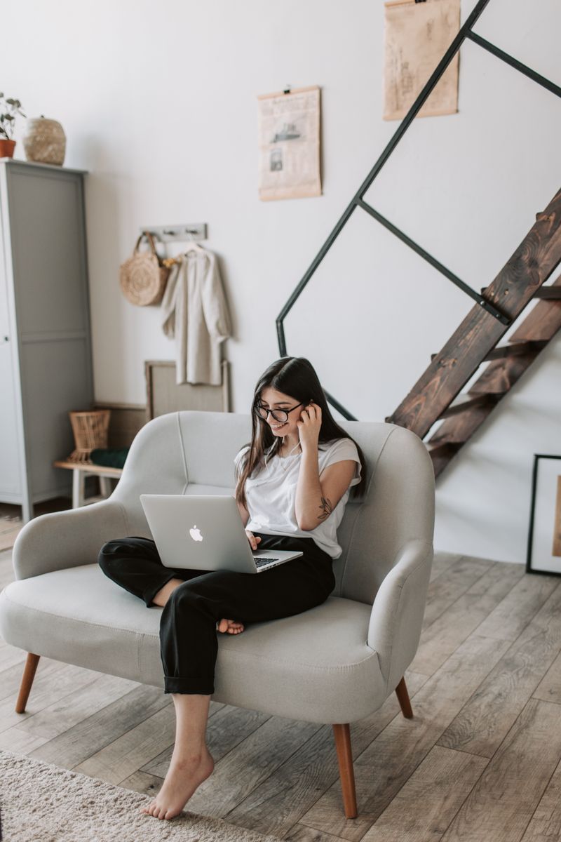 Mulher serena com laptop em casa — atendimento online acolhedor