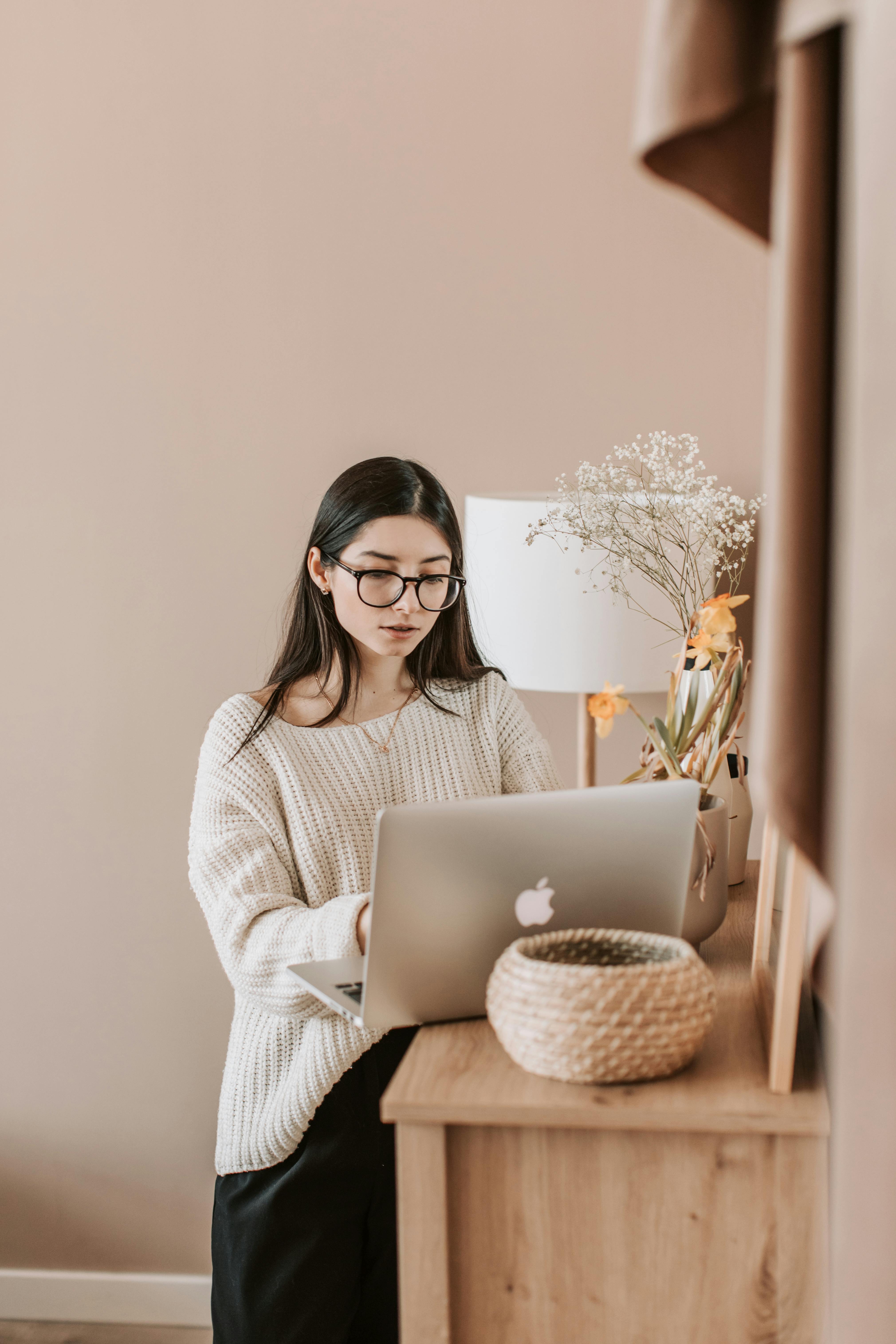 young female using laptop on commode in living room