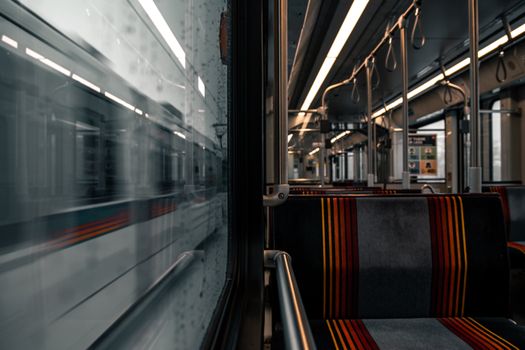 Empty seats and motion blur capture the essence of a modern subway train interior in transit.