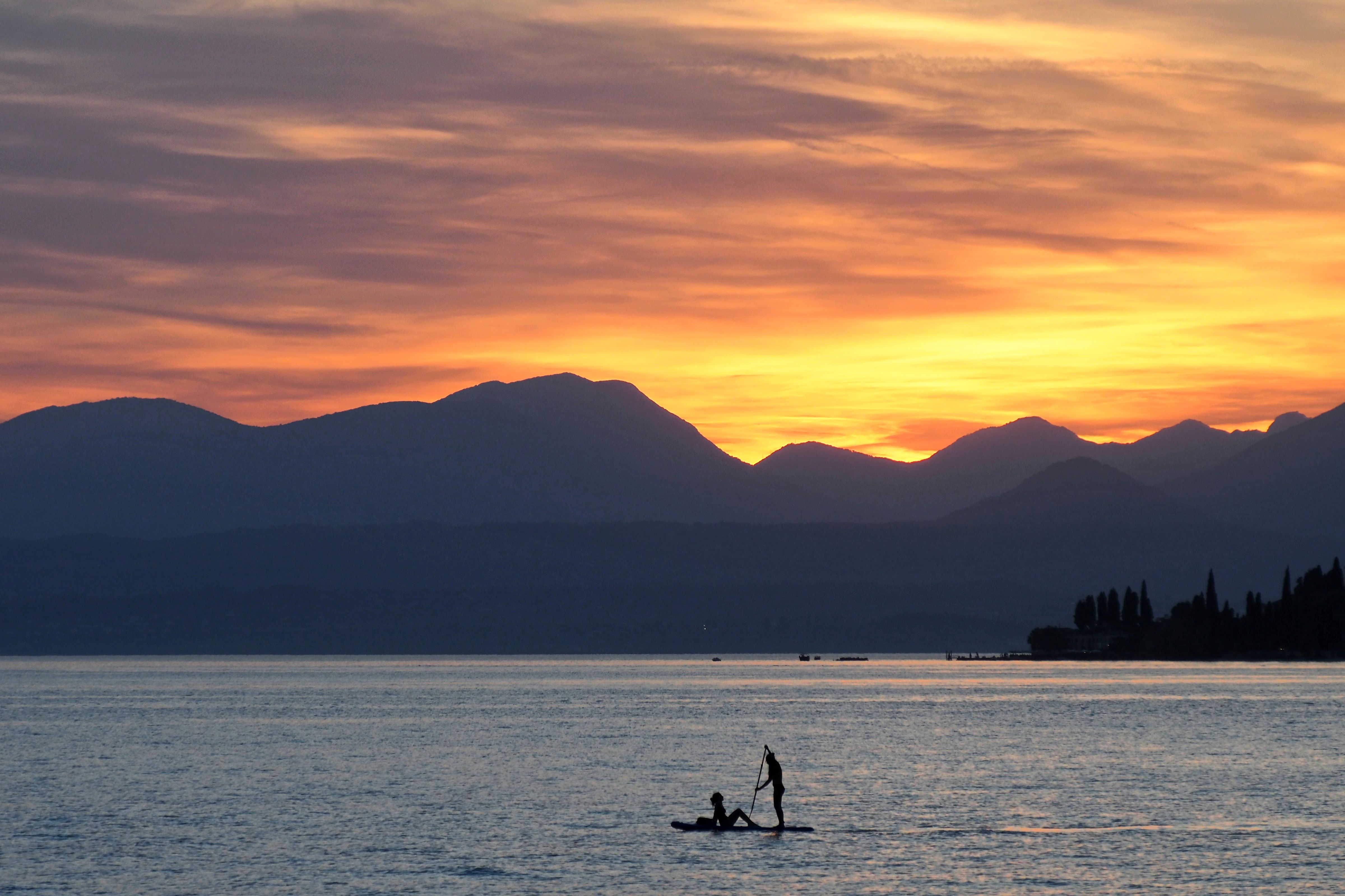Stunning Paddleboarding Sunset on Italian Lake · Free Stock Photo