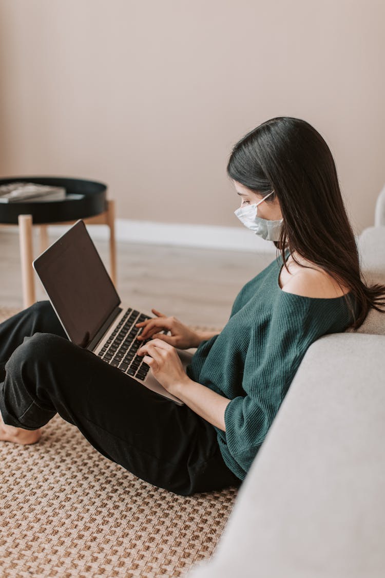 Female Remote Worker Typing On Laptop During Quarantine Period