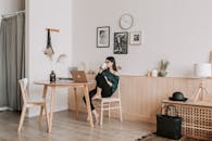 一位女士在舒适的家中，一边喝咖啡一边用笔记本电脑工作