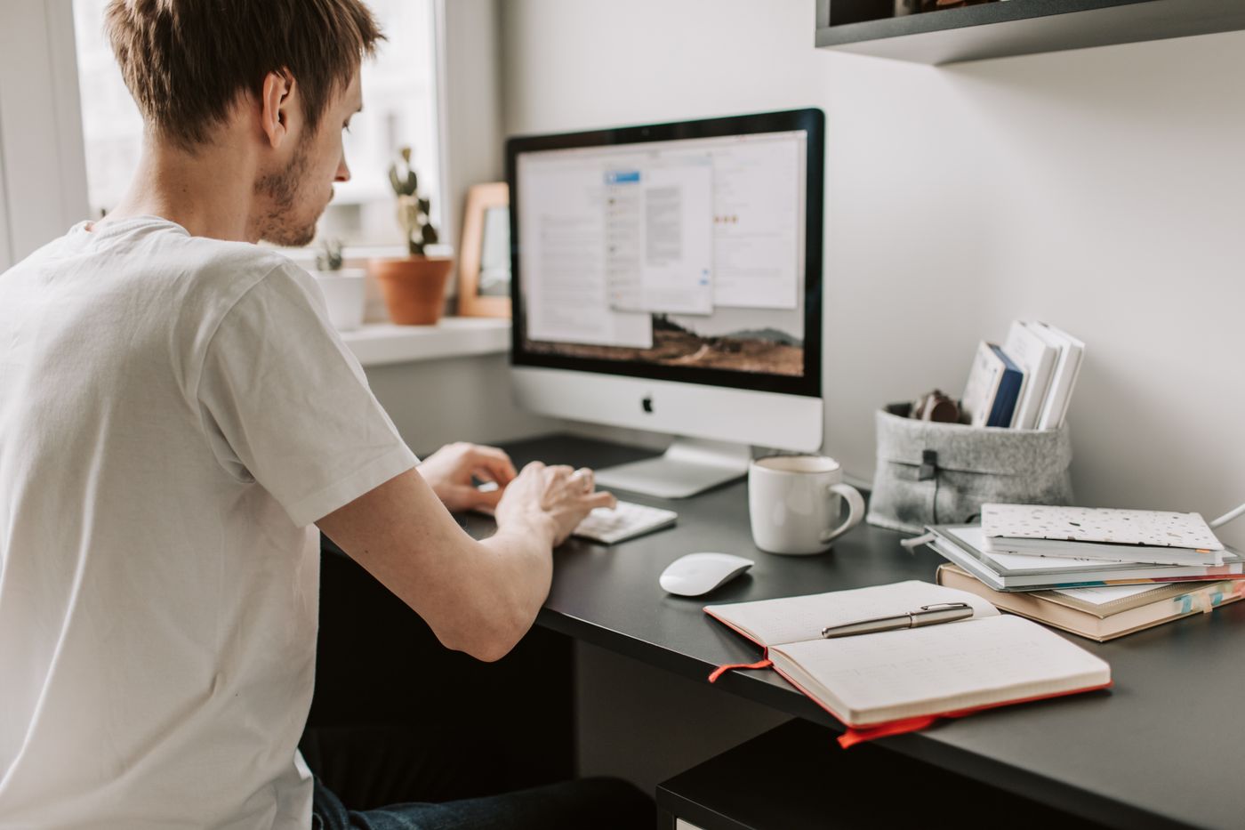 Pessoa utilizando computador em um ambiente doméstico de trabalho