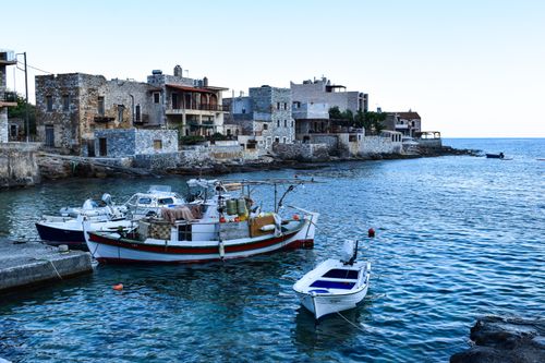 Free Explore the charming harbor of Gerolimenas, Greece, with traditional fishing boats docked at sunset. Stock Photo