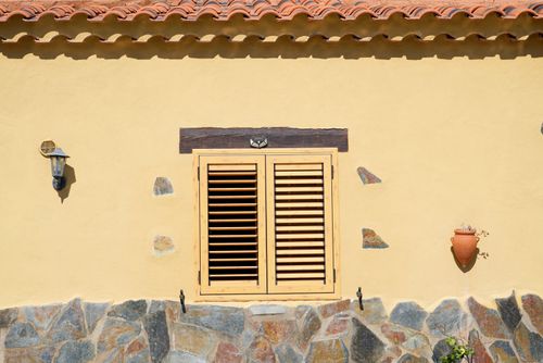 Free Exterior of creative house with wooden window located in countryside in summer sunny day Stock Photo