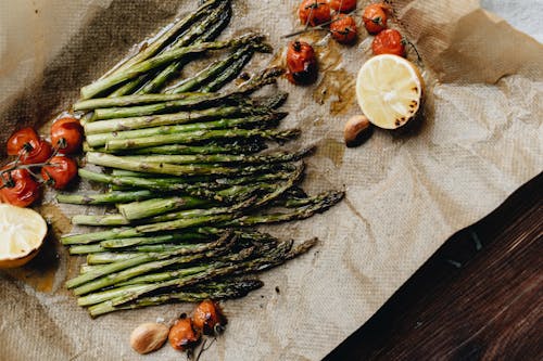 Photo Of Cooked Asparagus Near Cherry Tomatoes