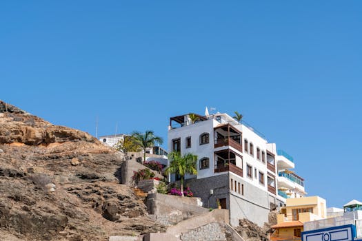 A picturesque modern residence on a cliffside with a clear blue sky backdrop.