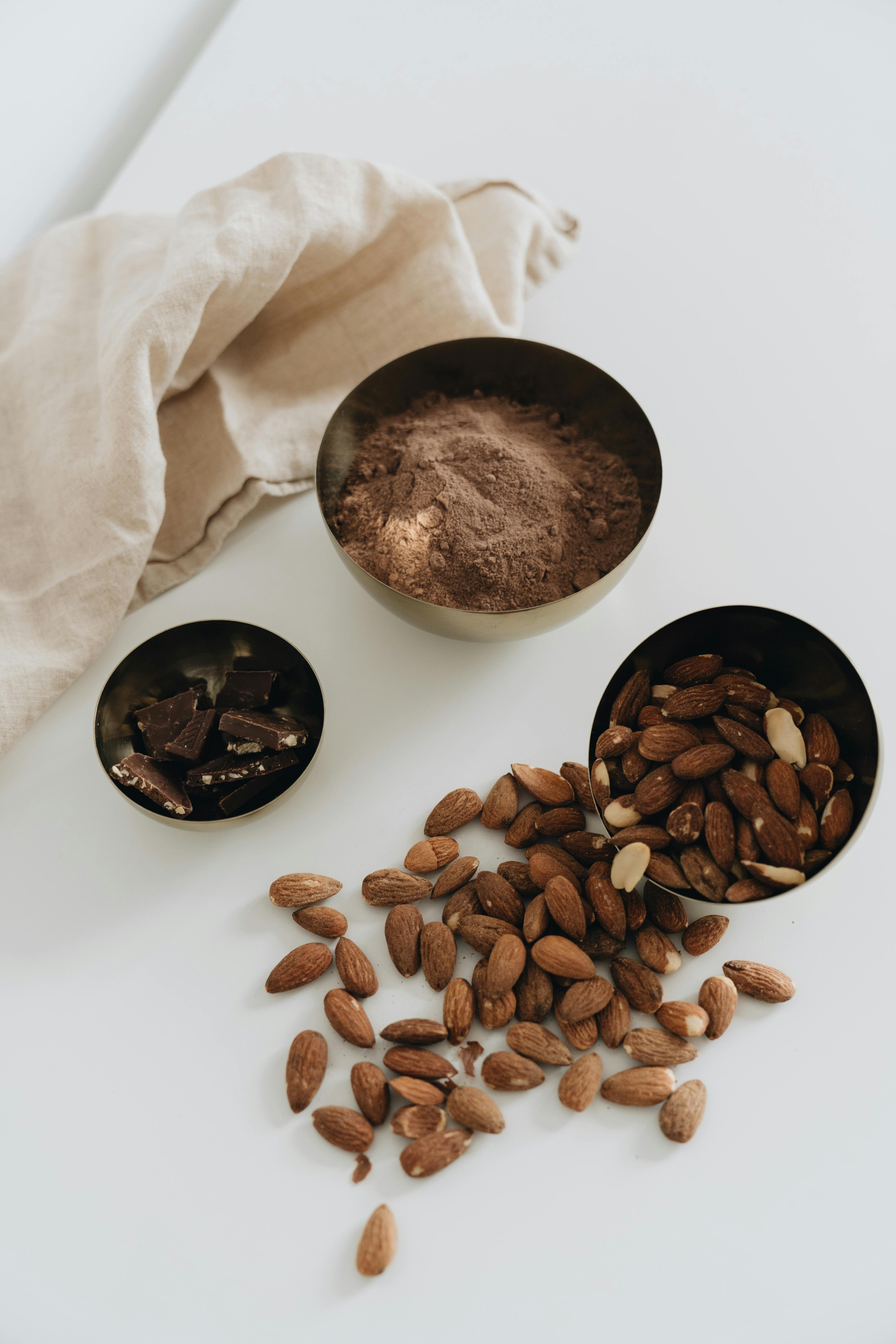 Photo Of Almonds Near Cocoa Powder · Free Stock Photo