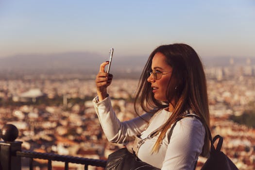 Young woman captures a selfie with cityscape backdrop during sunset, blending technology and travel.
