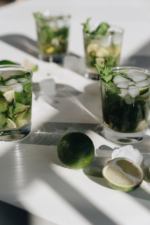 Free Refreshing mojito cocktail with lime and mint on a sunlit table, perfect for a summer drink. Stock Photo