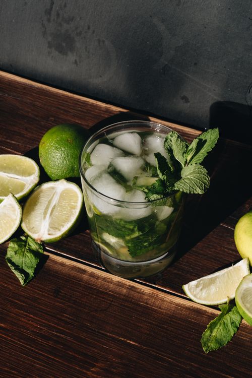 Free A cool and refreshing mojito with fresh lime and mint on a wooden table. Stock Photo