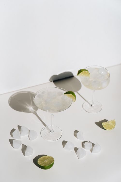 Free Two margarita cocktails garnished with lime wedges on a sunny day. Cool and refreshing. Stock Photo