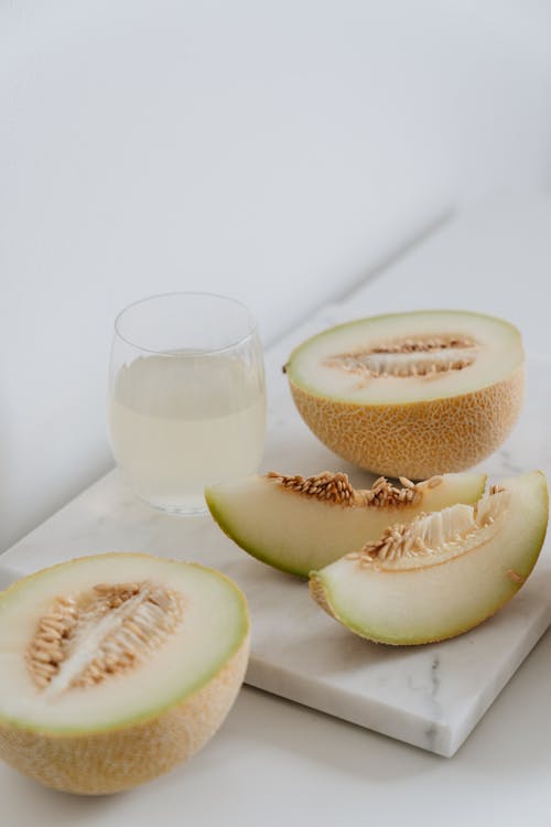 Photo Of Sliced Melon Beside Glass