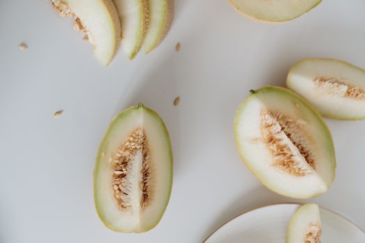 Top view of sliced melon with seeds on a white background, showcasing freshness and nutrition.