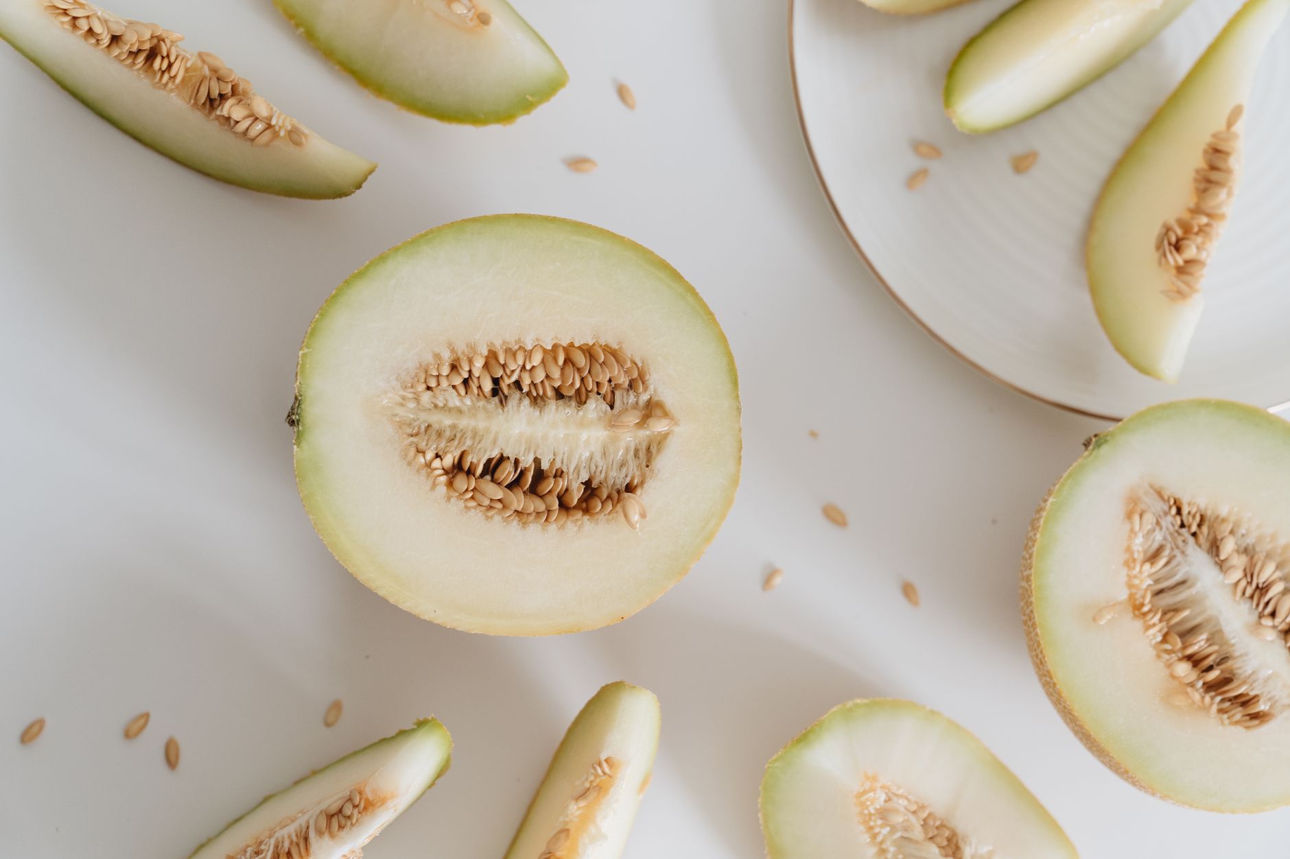 Cut cantaloupe pieces on a plate being enjoyed