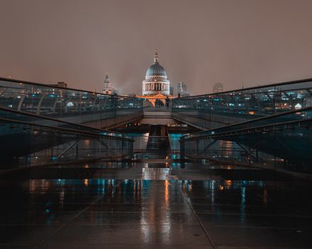 伦敦潮湿的千禧桥上，映照着圣保罗大教堂令人惊叹的夜间景观