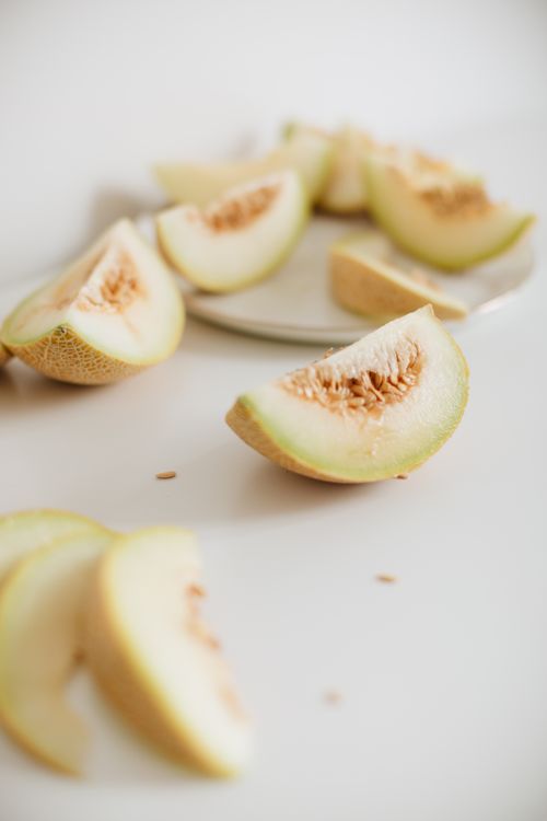 Sliced honeydew melon on a white surface — photo by alleksana on Pexels
