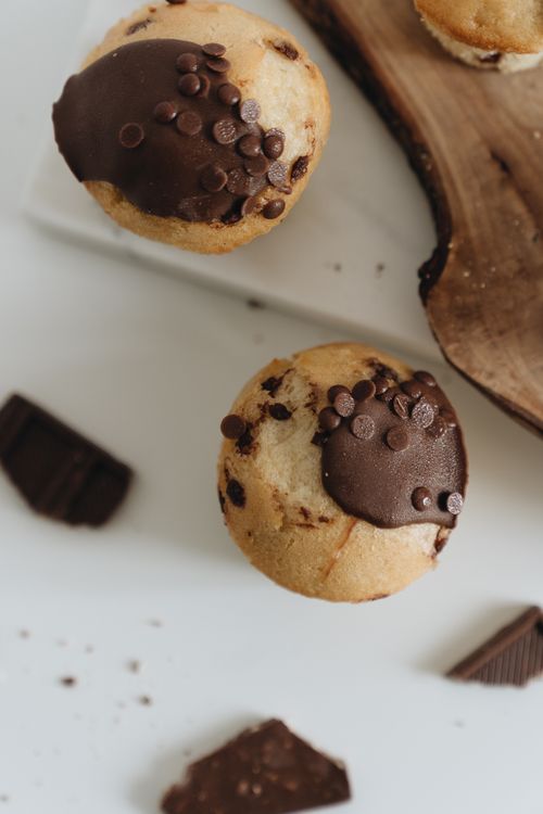 Free Delicious chocolate chip muffins with rich chocolate topping, styled on a rustic board. Stock Photo