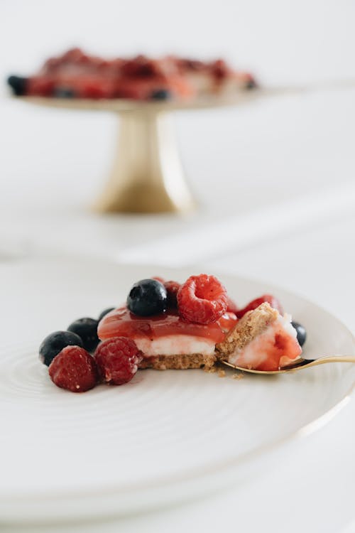 Selective Focus Photo of Cheesecake with Raspberries and Blueberries
