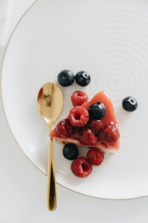 Overhead Shot of a Cheesecake Slice Beside a Gold Spoon