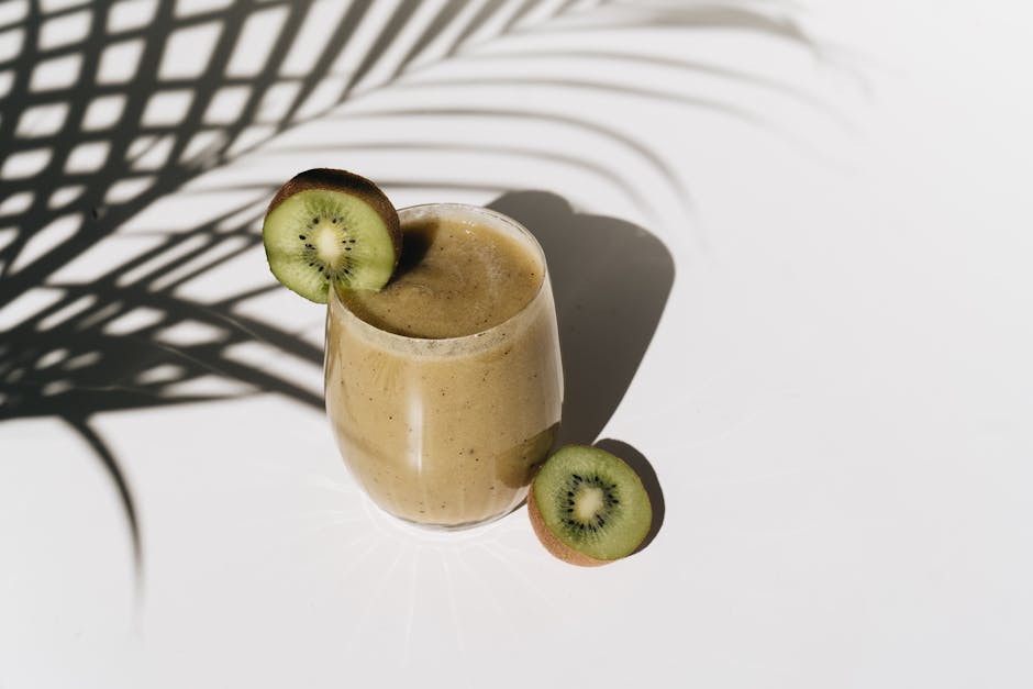 Smoothie Blender: 7 Things to Know Before You Buy A vibrant kiwi smoothie with palm leaf shadows creating a tropical feel.