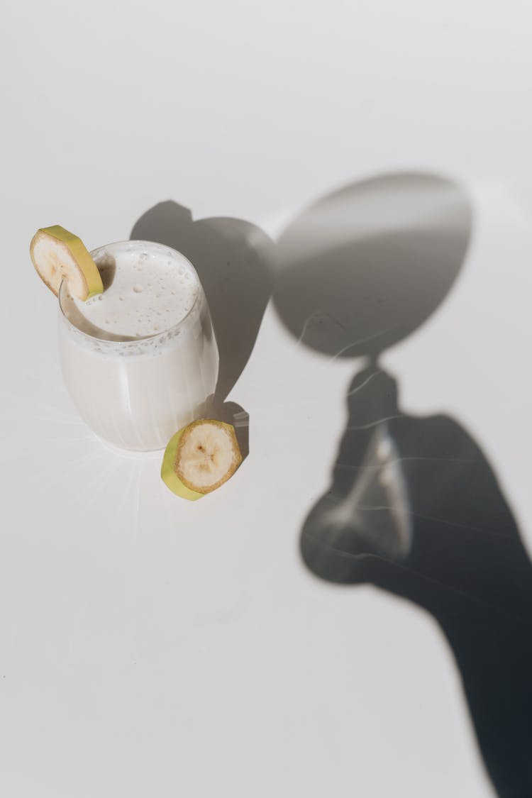 Cup With Banana Slice And Shadow Hand With Wineglass