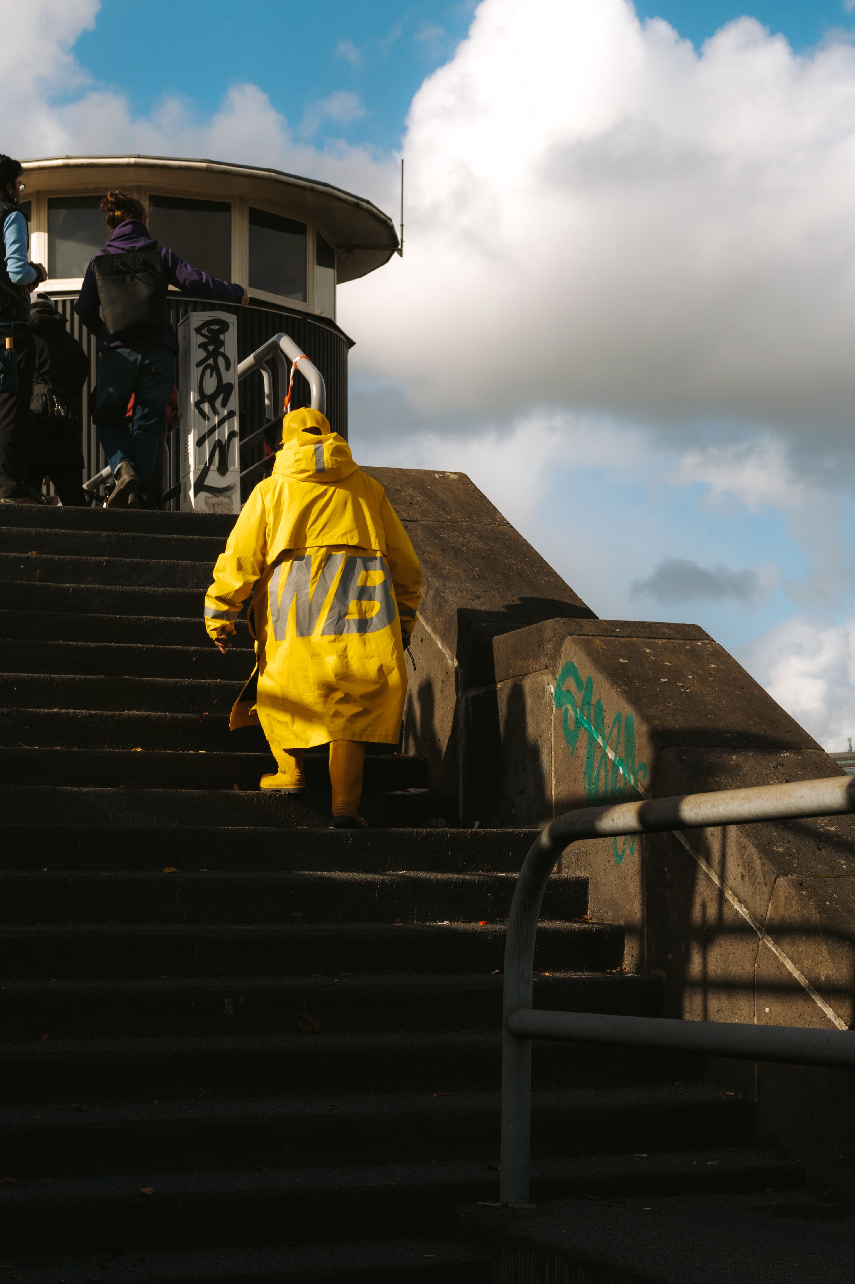 Person in Yellow Raincoat Climbing Steps · Free Stock Photo