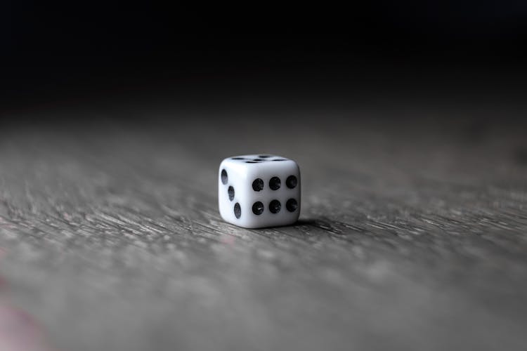 Small White Dice Placed On Wooden Table