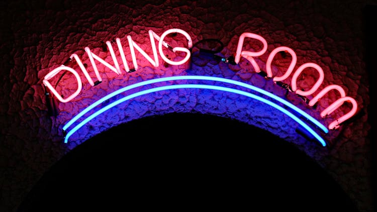 Illuminated Neon Pink And Blue Sign In Dark Cafe