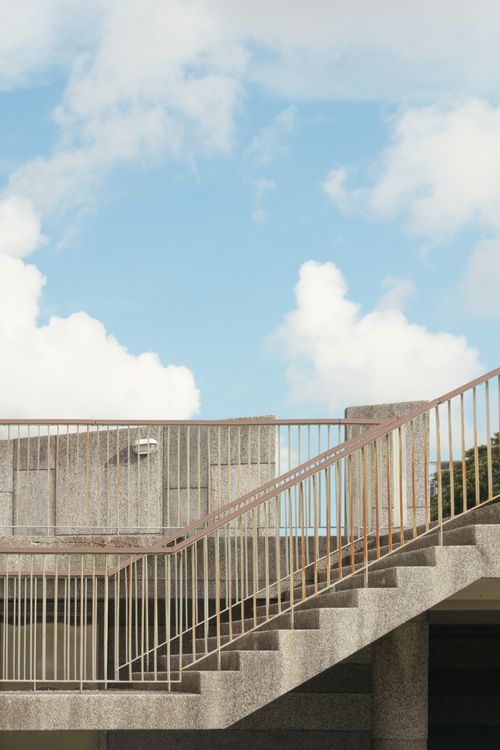 Free Modern concrete staircase with railing under a bright blue sky, featuring fluffy clouds in Kaohsiung, Taiwan. Stock Photo