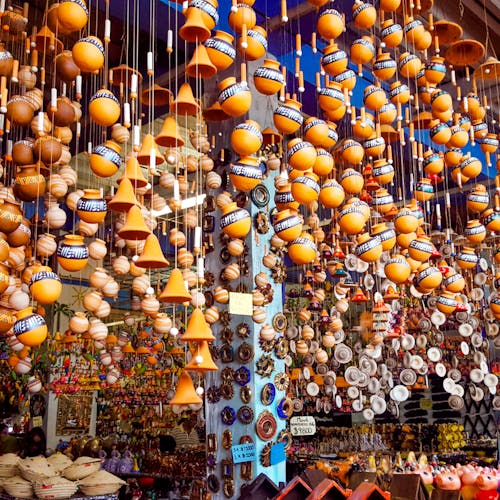 Low angle of various traditional lamps and clay products hanging on stall in local bazaar