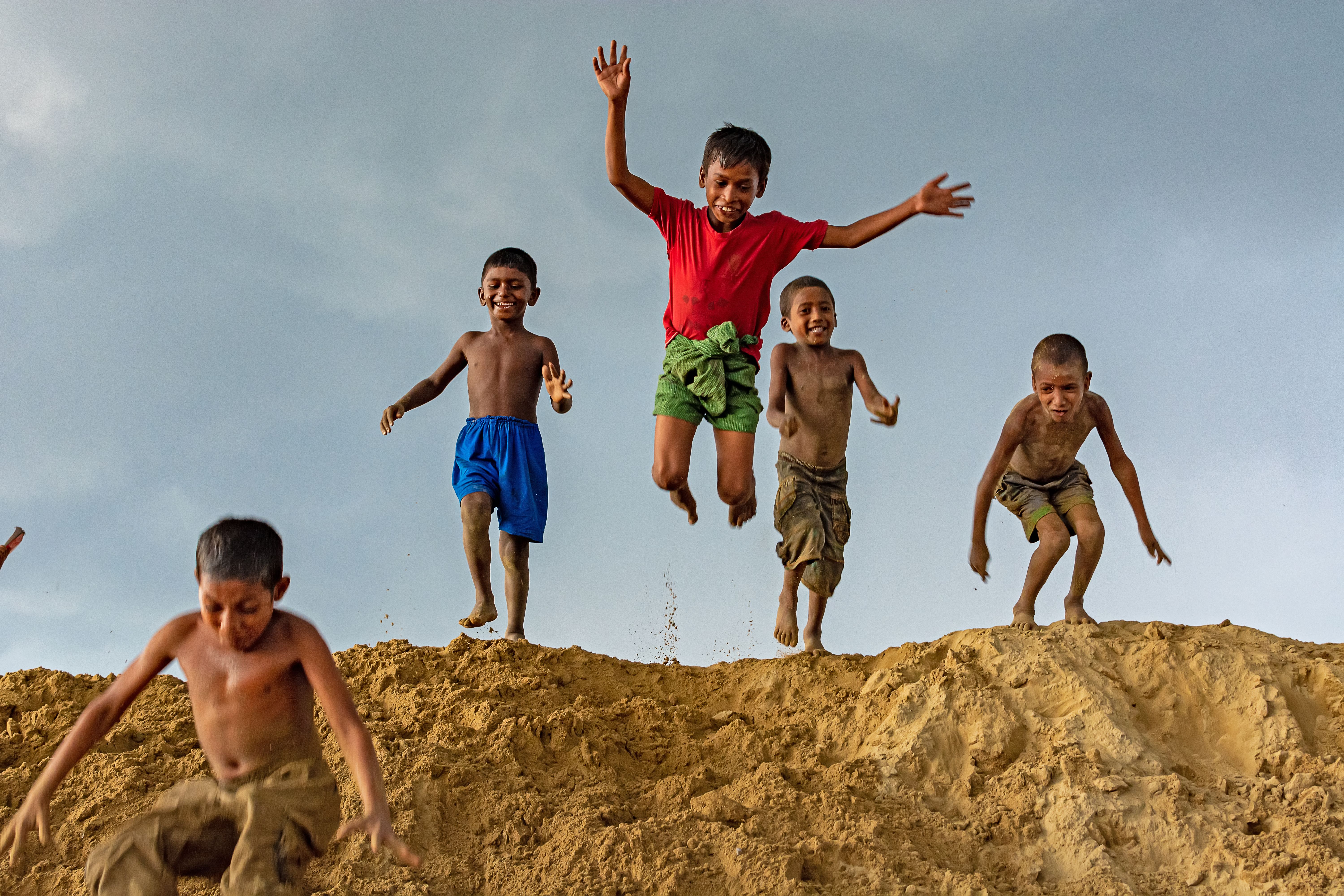 Joyful Children Jumping on Sandy Hill · Free Stock Photo