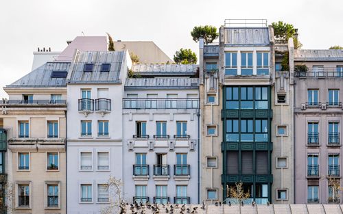 Free A picturesque view of a classic Parisian building facade with balconies and windows. Stock Photo