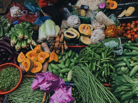 A colorful assortment of fresh vegetables displayed at a bustling outdoor market.