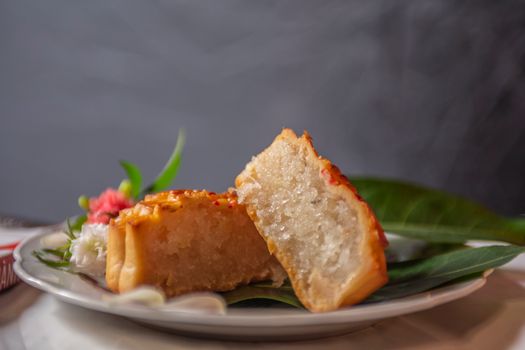Close-up of a sliced homemade yuca cake on a plate served with leaves, presenting a mouth-watering dessert.