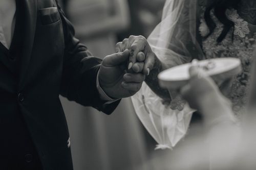 Free A black and white image capturing a touching moment of exchanging rings during a wedding ceremony. Stock Photo