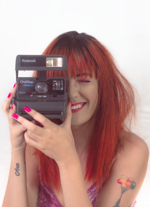 Photo Of Woman Holding Polaroid Camera