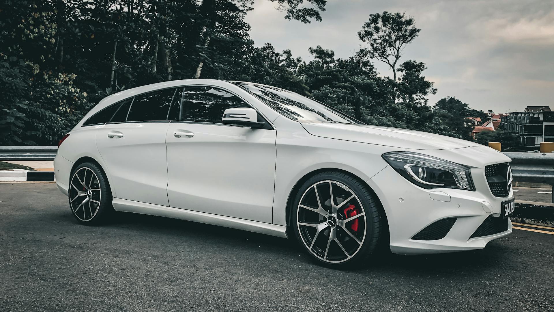 Sleek white Mercedes Benz parked in a Singapore urban setting, showcasing luxury design.